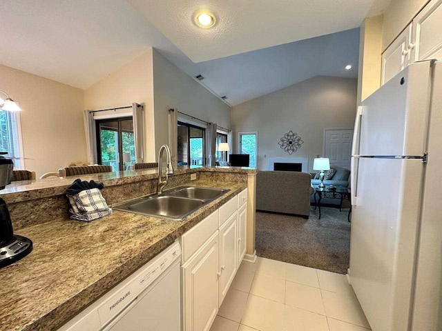 kitchen with white cabinetry, white appliances, sink, vaulted ceiling, and light tile patterned flooring