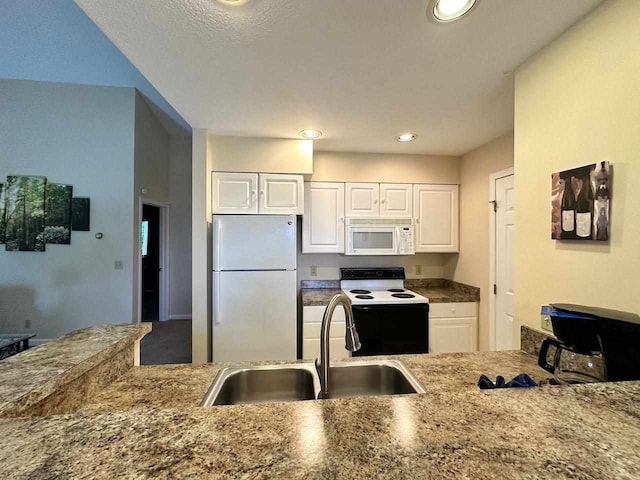 kitchen with white appliances, sink, white cabinets, and a textured ceiling