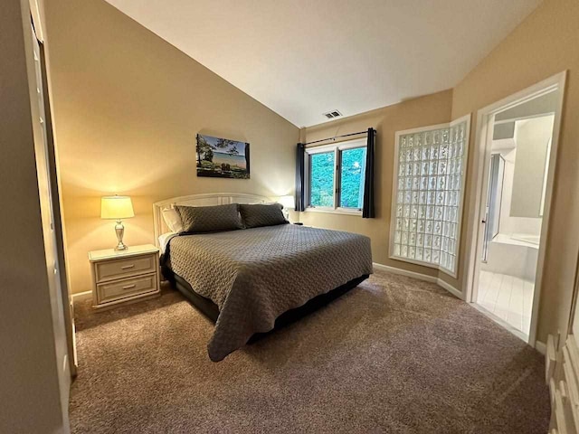 bedroom with carpet, ensuite bathroom, and vaulted ceiling