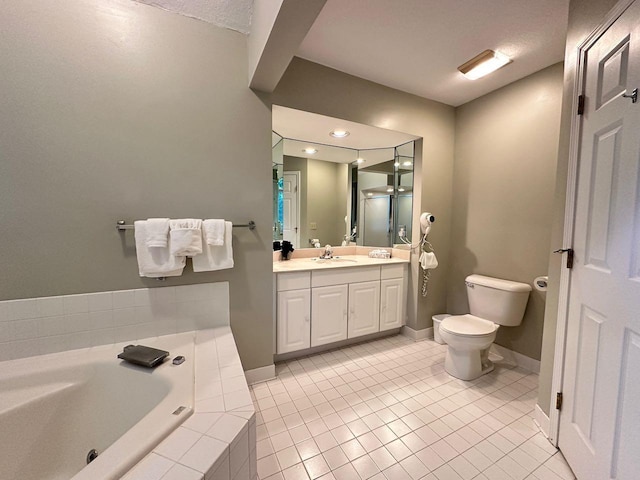 bathroom featuring a textured ceiling, vanity, tile patterned flooring, toilet, and tiled tub