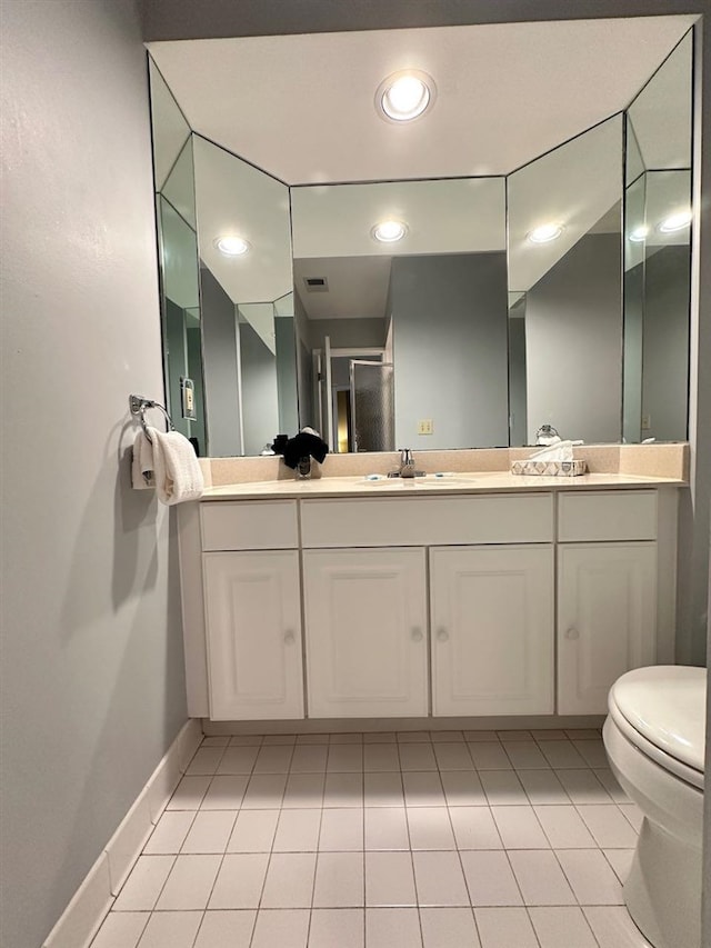 bathroom featuring vanity, toilet, walk in shower, and tile patterned flooring