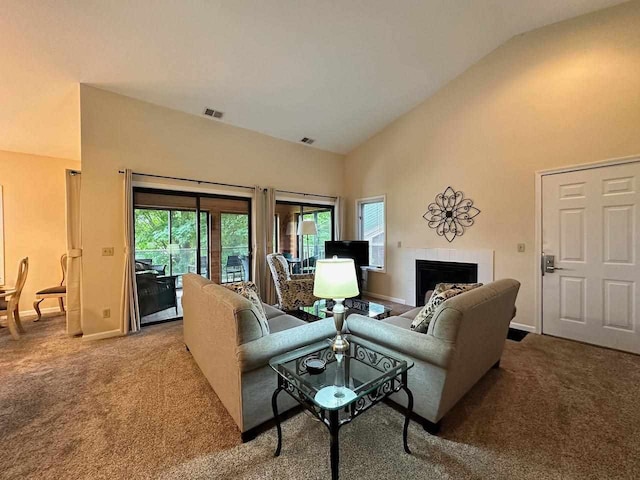 carpeted living room featuring high vaulted ceiling