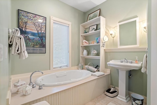 full bath with tile patterned flooring, a garden tub, and baseboards