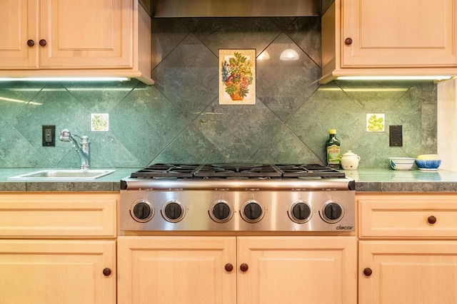 kitchen with a sink, extractor fan, backsplash, and stainless steel gas cooktop