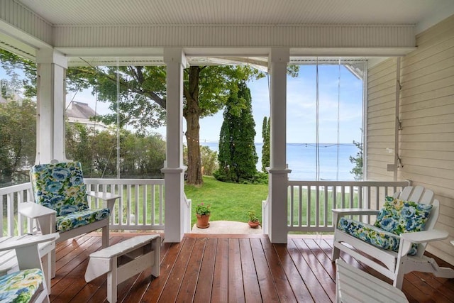 sunroom / solarium featuring a water view