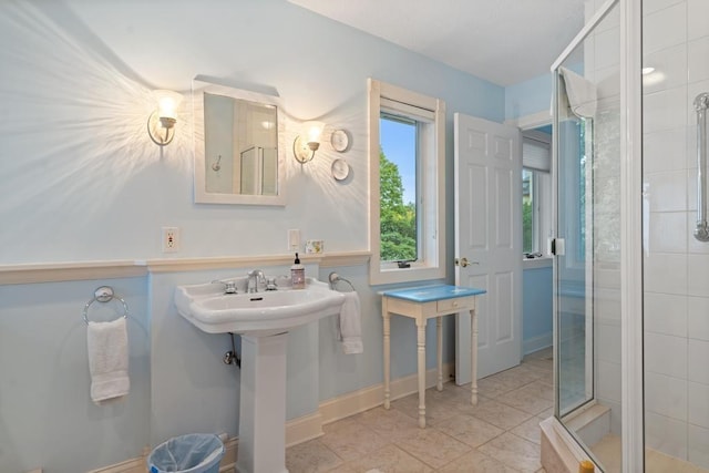 bathroom with tile patterned floors, a stall shower, and a sink