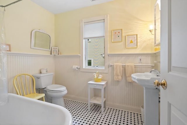 bathroom with wainscoting and toilet