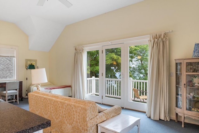 carpeted living area with ceiling fan and vaulted ceiling