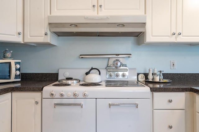 kitchen with under cabinet range hood, white appliances, white cabinetry, and dark countertops