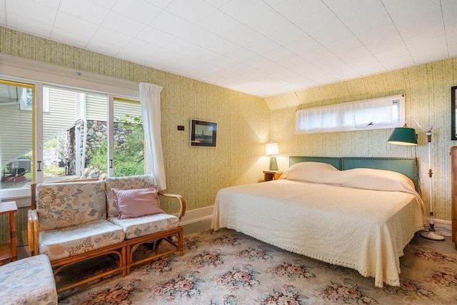 bedroom featuring baseboards and wallpapered walls