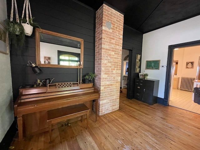 miscellaneous room with light wood-type flooring and wooden walls