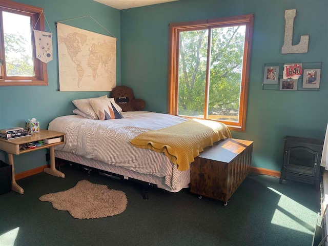 bedroom featuring a wood stove and carpet floors