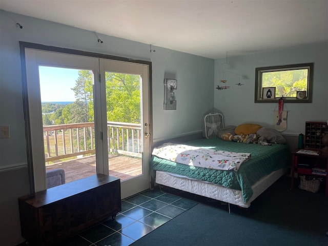 bedroom with dark tile patterned flooring and access to exterior