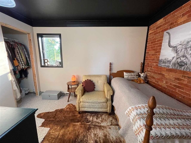 carpeted bedroom with brick wall and a closet