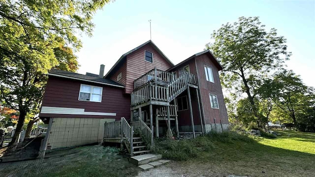 back of property with a yard and a wooden deck