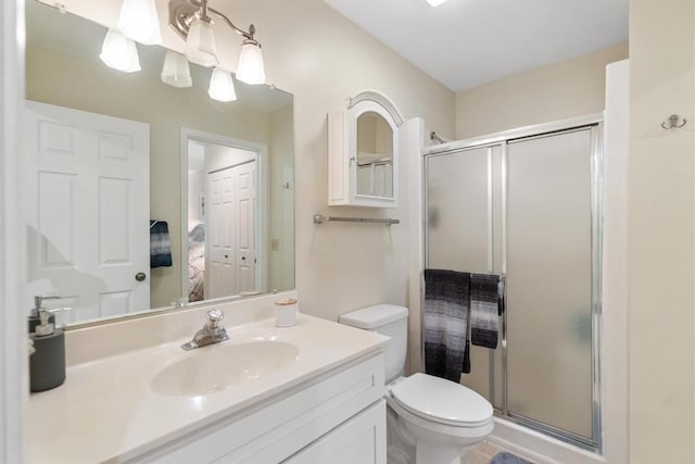 bathroom featuring vanity, toilet, and an enclosed shower