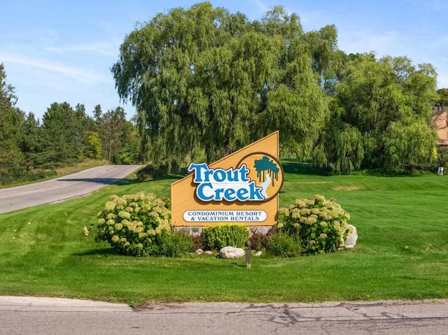 community / neighborhood sign featuring a yard