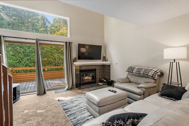 living room featuring a tiled fireplace and carpet