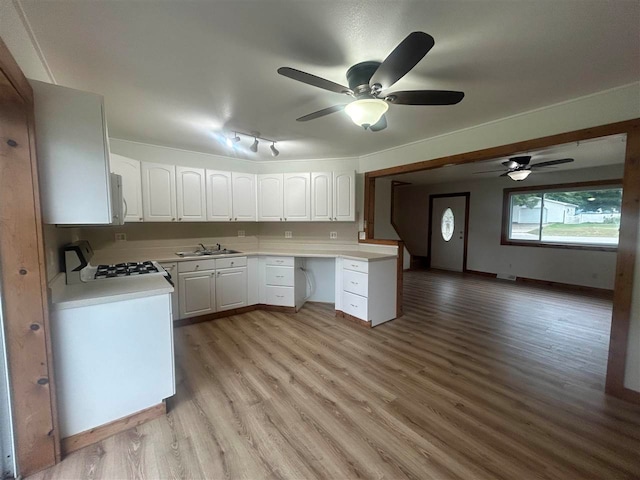 kitchen with light hardwood / wood-style floors, sink, white cabinetry, white appliances, and ceiling fan