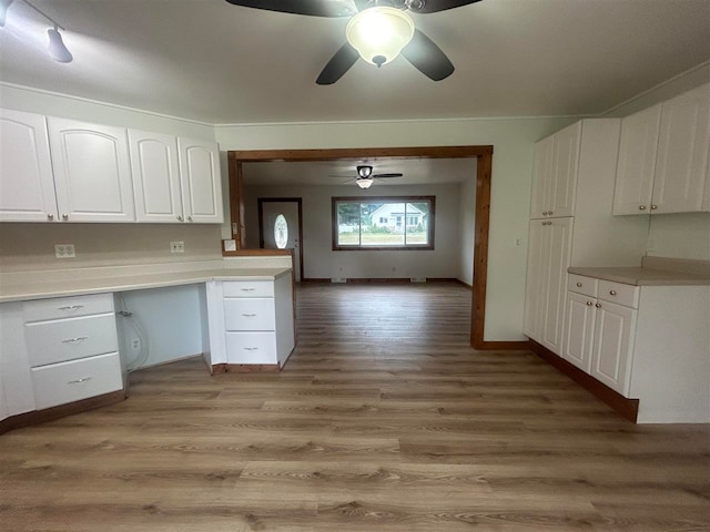 kitchen featuring light hardwood / wood-style flooring, built in desk, white cabinetry, and ceiling fan