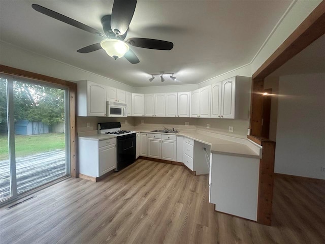 kitchen with light hardwood / wood-style floors, sink, white cabinets, white appliances, and ceiling fan