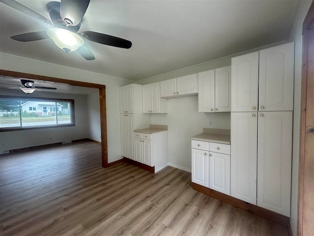 kitchen with white cabinets, light hardwood / wood-style floors, and ceiling fan