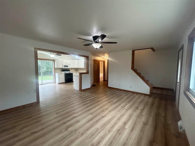 unfurnished living room with ceiling fan and light hardwood / wood-style floors