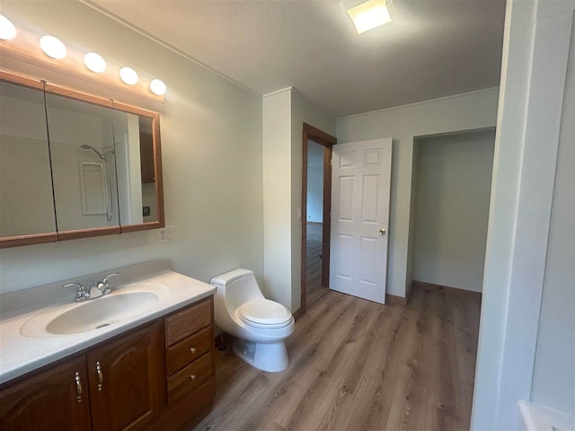 bathroom featuring a textured ceiling, hardwood / wood-style flooring, vanity, and toilet