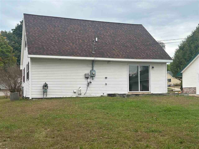 back of house with a lawn and central AC