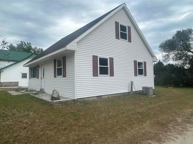 view of side of property featuring a yard and central air condition unit