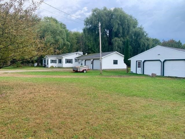 view of yard featuring a garage and an outdoor structure