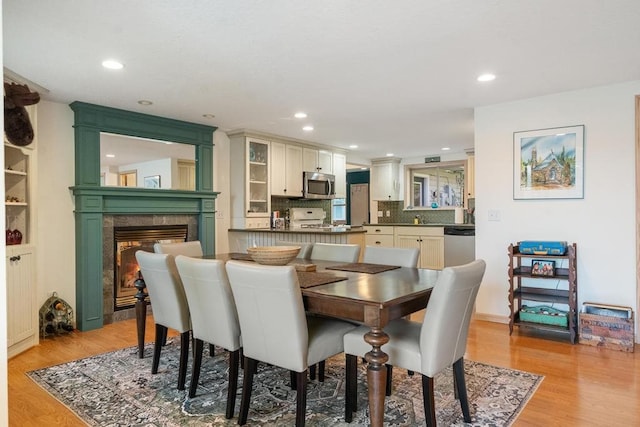 dining room featuring light hardwood / wood-style flooring and a tile fireplace