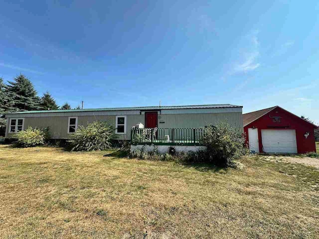 manufactured / mobile home with an outbuilding, a garage, and a front lawn