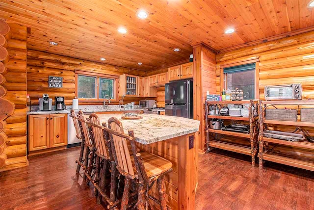 kitchen with black fridge, rustic walls, dark hardwood / wood-style floors, and wood ceiling