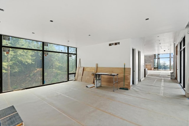3087 Forrest Ave, Harbor Springs, MI 49740 - empty room featuring a wall of windows and concrete floors