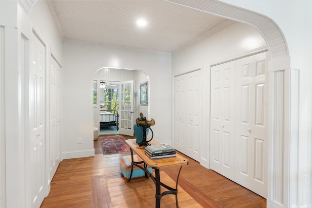 corridor featuring wood-type flooring and crown molding