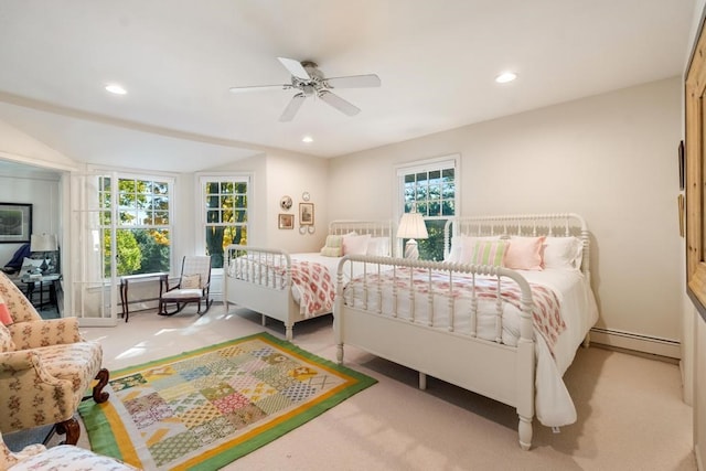 bedroom featuring ceiling fan, light colored carpet, and a baseboard heating unit