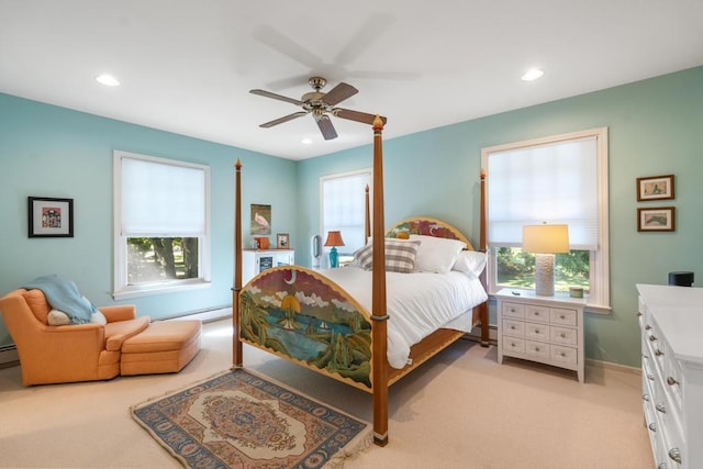 carpeted bedroom with multiple windows, baseboard heating, and ceiling fan