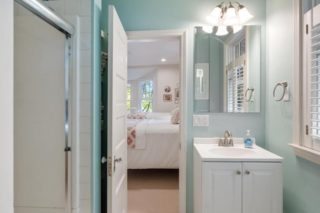 bathroom with a chandelier, a shower with door, and vanity