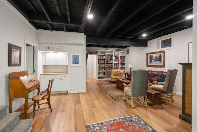 sitting room with beamed ceiling and light hardwood / wood-style floors