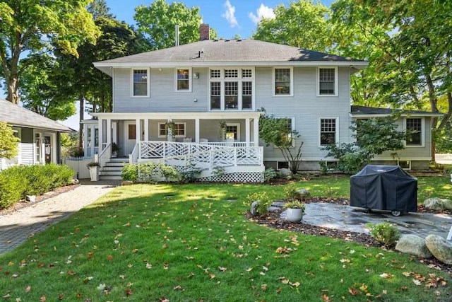 rear view of property with a yard and covered porch