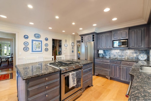 kitchen featuring dark stone counters, stainless steel appliances, light hardwood / wood-style floors, and decorative backsplash