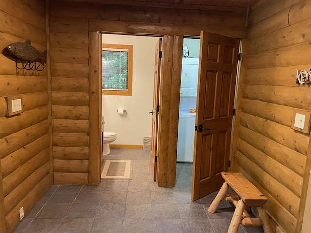 bathroom featuring toilet and rustic walls