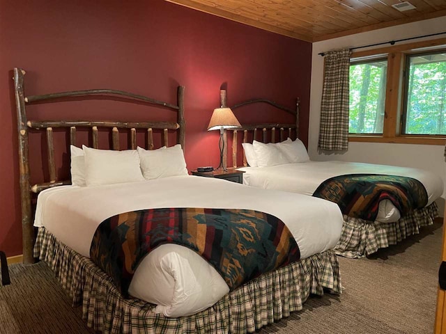 carpeted bedroom featuring wooden ceiling