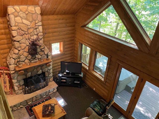 living room featuring a fireplace, rustic walls, wooden ceiling, and a wealth of natural light