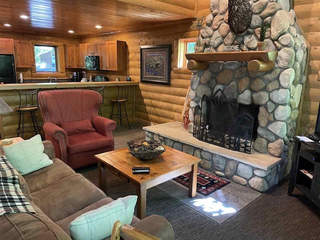 living room with a stone fireplace, wood ceiling, and rustic walls