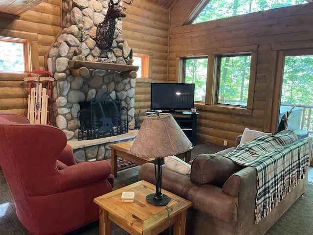 living room with log walls, plenty of natural light, and a stone fireplace