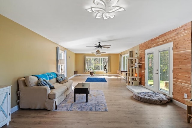 living room featuring wooden walls, hardwood / wood-style floors, and ceiling fan