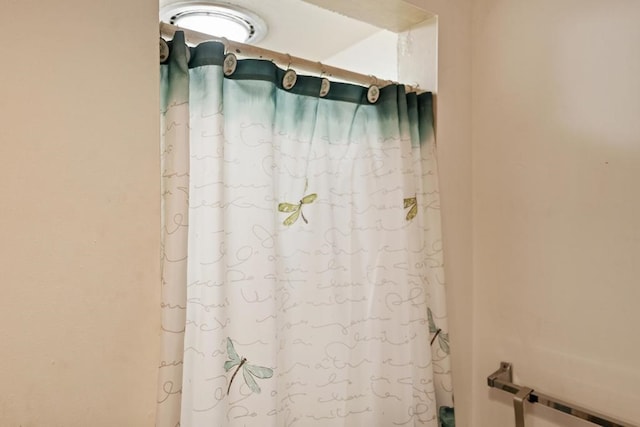 interior details featuring a shower with shower curtain