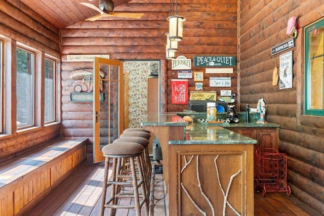 bar with wood-type flooring, rustic walls, and lofted ceiling
